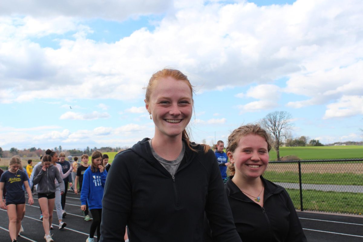 Track Coach Profe Van Sluys leads her team in warm ups with a look of pure joy.

