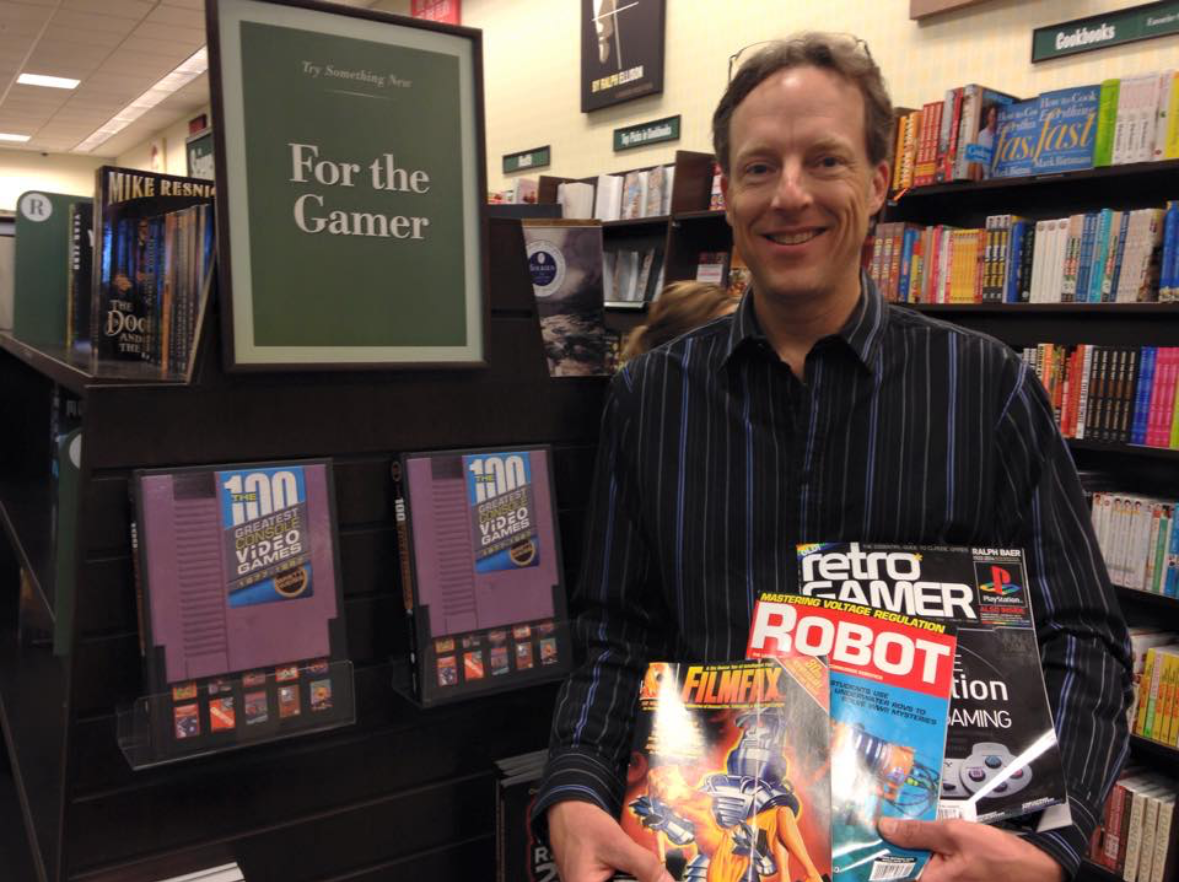 Brett Weiss holding his book that he wrote.